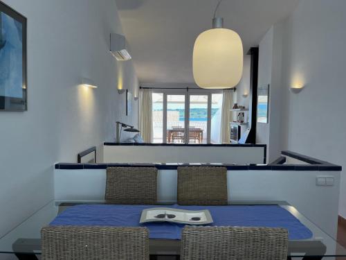 a dining room with a table and chairs with a plate on it at Riera Rossello 1 by SOM Menorca in Fornells