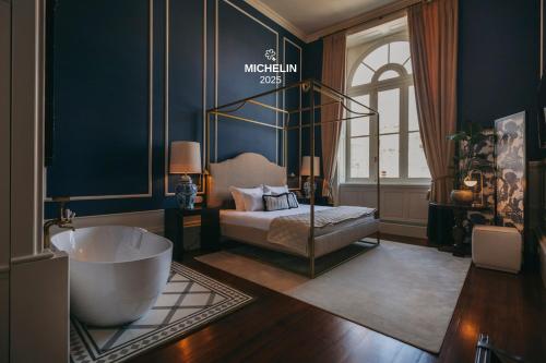 a bathroom with a tub and a bed in a room at Torel 1884 Suites & Apartments in Porto