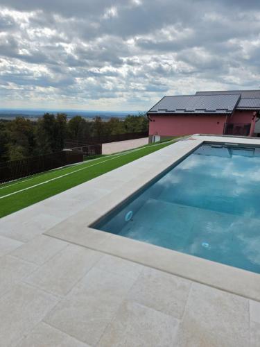 a swimming pool on the side of a house at Marmor Collis by Winery Glavica in Gornja Gračenica
