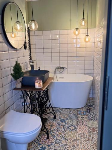 a bathroom with a tub and a toilet and a sink at UNESCO Loft House 24h Tarnowskie Góry Rynek 5 min in Tarnowskie Góry
