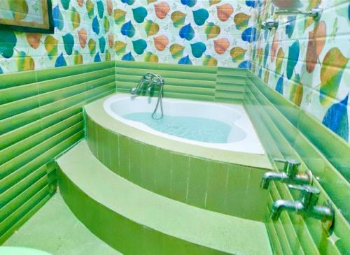 PūrnānkuppamCeleste Luxury Bungalow的绿色墙壁上设有水槽的浴室