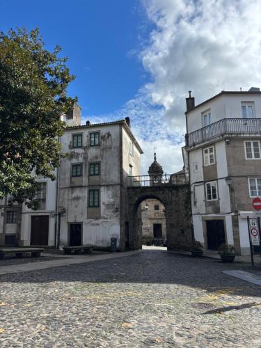 an old building with an archway in a courtyard at Pension Via-Stella in Santiago de Compostela