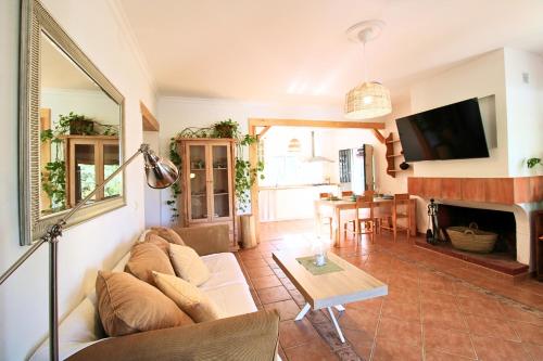 a living room with a couch and a table at Casa Rural El Membrillo by SIERRA VIVA in Jabuguillo