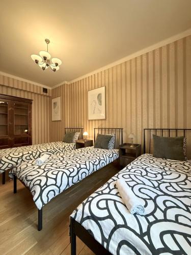 due letti uno accanto all'altro in una stanza di 15 Gdynia - Duże mieszkanie w Centrum dla 9 osób a Gdynia