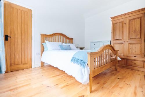 a bedroom with a wooden bed and a wooden dresser at Superb Location - 'The Annexe' - at Ty Moel Isaf in Amlwch