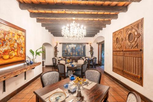 Un comedor con una mesa y sillas y una lámpara de araña. en Las Cruces Boutique Hotel, en Antigua Guatemala