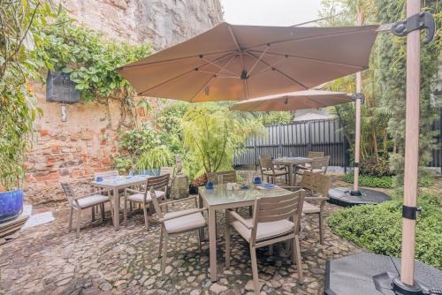 Un patio con mesas y sillas y una sombrilla. en Las Cruces Boutique Hotel, en Antigua Guatemala
