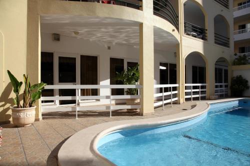 a swimming pool in front of a building at Aparthotel Calema Avenida Jardim in Monte Gordo