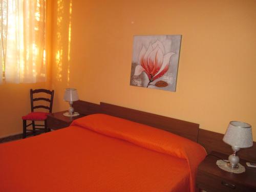 a bedroom with a bed with an orange blanket at Villa Sortino in Ribera
