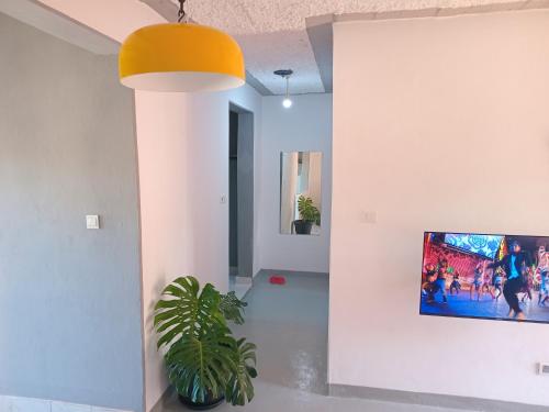 a living room with a tv on a wall at Truenorth Apartments siem in Ukunda