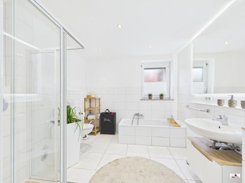 a white bathroom with a tub and a sink at Winter Garden Dream Steinheim in Steinheim an der Murr