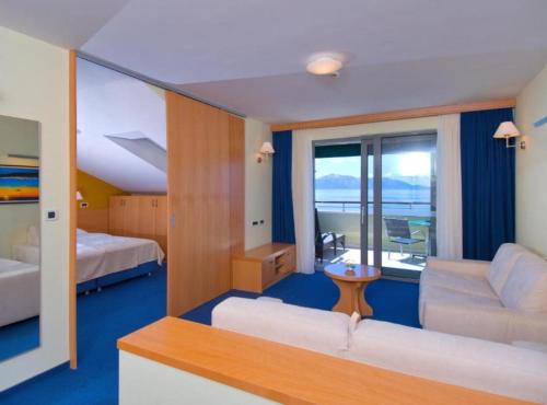 een kamer met 2 bedden, een bank en een tafel bij Boutique Hotel Saudade in Mlatinje