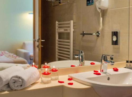 een badkamer met een wastafel en een bad met rode rozen erop bij Boutique Hotel Saudade in Mlatinje