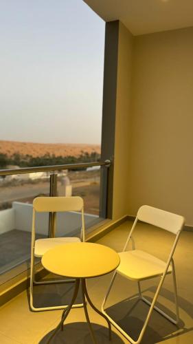 two chairs and a table in front of a window at Dune View Luxury Villas in Ḩawīyah