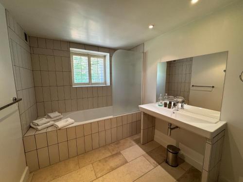 a bathroom with a tub and a sink and a mirror at La porte d'Arcy in Fère-en-Tardenois