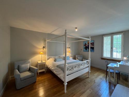 a bedroom with a canopy bed and a chair at La porte d'Arcy in Fère-en-Tardenois