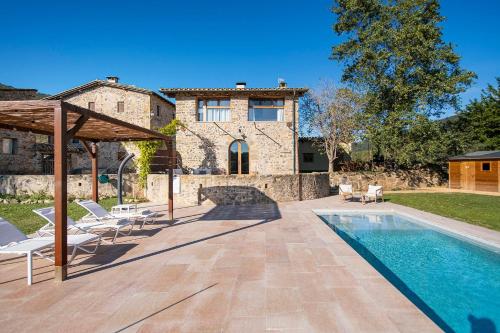 a villa with a swimming pool and a house at El Graner i El Niu in Sant Jaume de Llierca