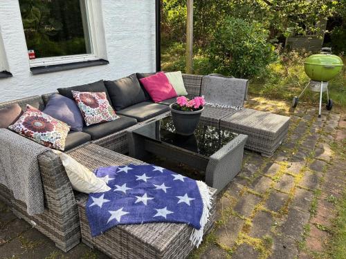 a couch with patriotic pillows on a patio at Close to Gothenburg & the sea - with your own sauna! in Billdal