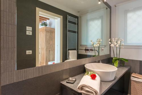 une salle de bain avec un lavabo et un grand miroir dans l'établissement Villa Le Panteraie con piscina, à Montecatini Alto