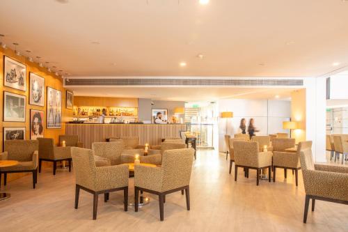 a restaurant with chairs and tables and a bar at VIP Executive Azores Hotel in Ponta Delgada