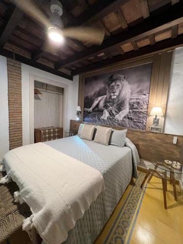 a bedroom with a large bed with a picture of a lion at Los Ángeles de Sanmartín in Jimena de la Frontera