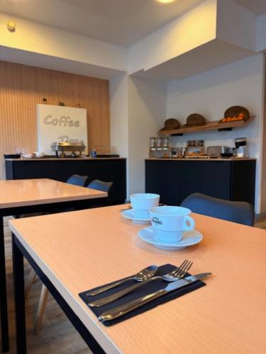 Una mesa con utensilios encima en un restaurante. en Brit Hotel L'Arrivée Guingamp, en Guingamp