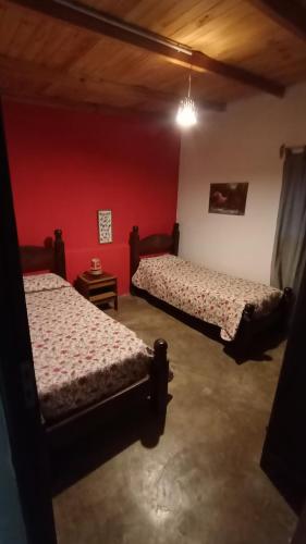 two beds in a room with red walls at Corazonada in Volcán