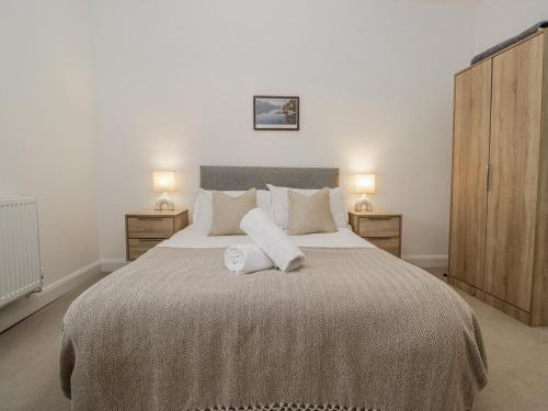 a bedroom with a large bed with two towels on it at Ullswater in Ulverston