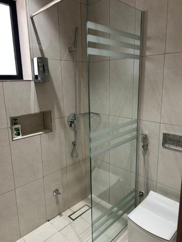 a bathroom with a glass shower with a toilet at قمرة قباء Cuba moon2 in Medina