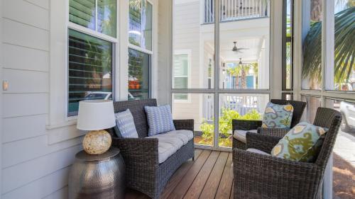 una veranda schermata con sedie in vimini e un divano di That Summer Feeling a Inlet Beach