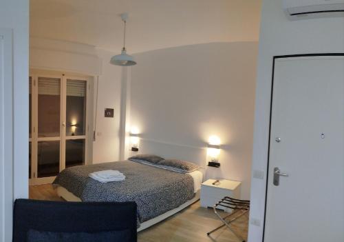a white bedroom with a bed and a chair at Town Center Apartment in Cagliari