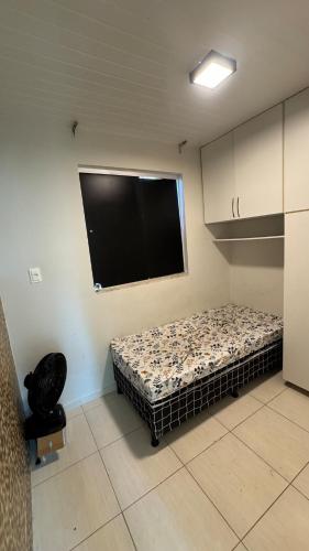 a room with a bed and a flat screen tv at Casa aconchegante com piscina e wi-fi rápido in Aracaju