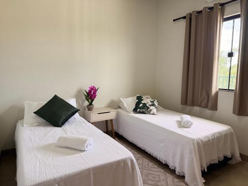 two beds sitting next to each other in a room at Apartamento com Varanda e Ar Condicionado in Sinop