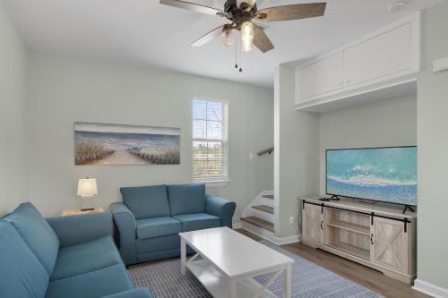 锡格罗夫海滩The Bungalows at Seagrove 114的客厅里有一张蓝色沙发和一台电视