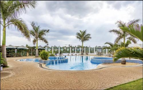 a pool at a resort with palm trees at Cozy 2 BR Tatu City - Unity Homes in Oloyaingalani