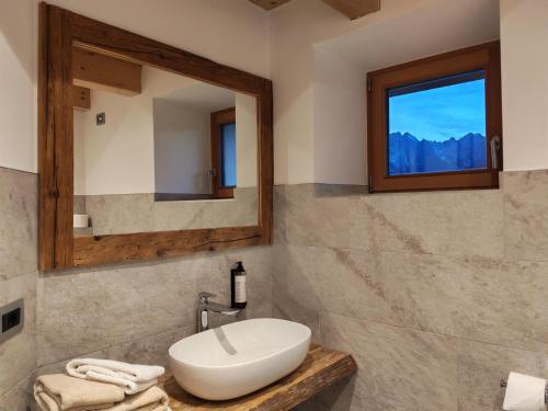 a bathroom with a sink and a mirror at Al Sole B&B Valcomelico in Santo Stefano di Cadore