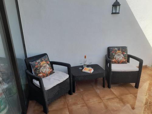 Dos sillas y una mesa en una habitación. en Casa Carla, en Granadilla de Abona