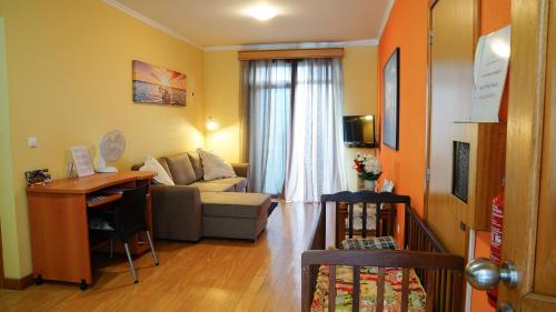 a living room with a couch and a table at Apartamento Barros in Estreito de Câmara de Lobos