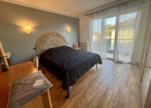 Ένα ή περισσότερα κρεβάτια σε δωμάτιο στο Villa Amistad - Chambre Erable - centre - parking - jardin - logement partagé -