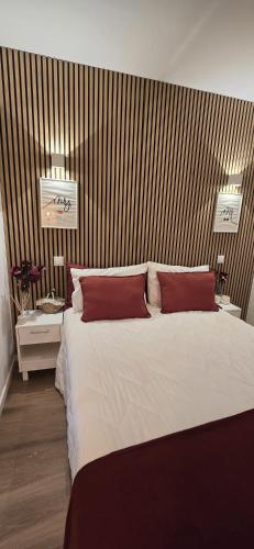 a bedroom with a large white bed with red pillows at Bivar Urban Retreat in Lisbon
