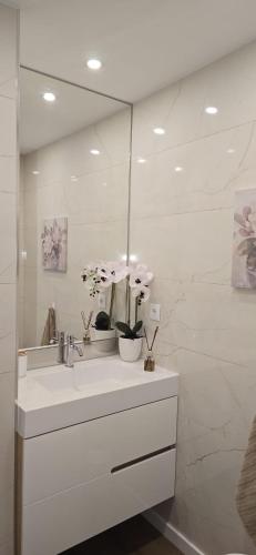 a white bathroom with a sink and a mirror at Bivar Urban Retreat in Lisbon