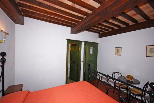 a bedroom with an orange bed and a table and chairs at A La Casa Dei Potenti in San Gimignano