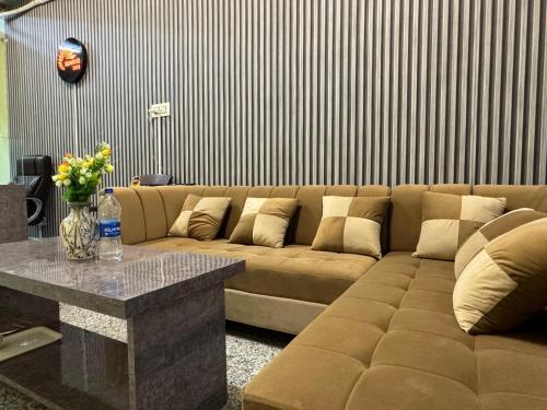 a living room with a brown couch and a table at SUNRISE INN hotel in Bikaner