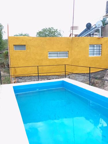 a swimming pool in front of a yellow building at Casa de alquiler 2 in Tanti