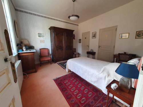 1 dormitorio con cama blanca y alfombra roja en Mer et Style, en Cabourg