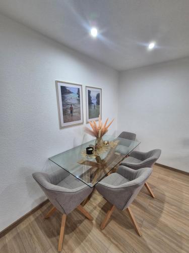 a dining room with a glass table and chairs at Apartmán LUX Lučenec in Lučenec
