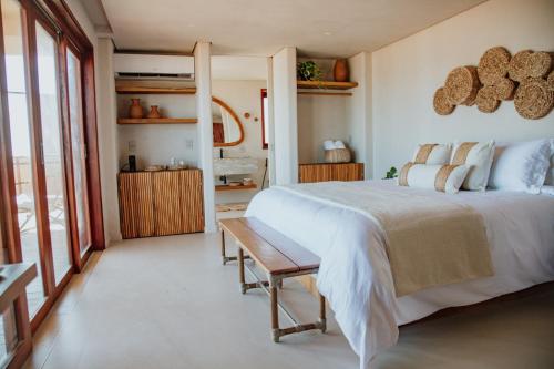 Un dormitorio con una cama grande y una mesa. en Lahaina Hotel, en Amontada