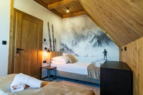 a bedroom with a bed with a painting on the wall at TATRZAŃSKIE TARASY Luxury Chalets in Małe Ciche