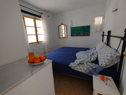 a bedroom with a bed and a bowl of fruit on a counter at Apartament Maria F in Mojácar