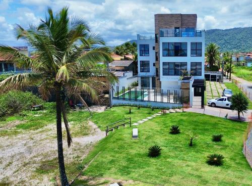 a palm tree in front of a house at Acqua Di Mare Pousada in Itanhaém